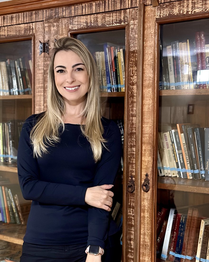 Priscila Rosini in front of a bookcase